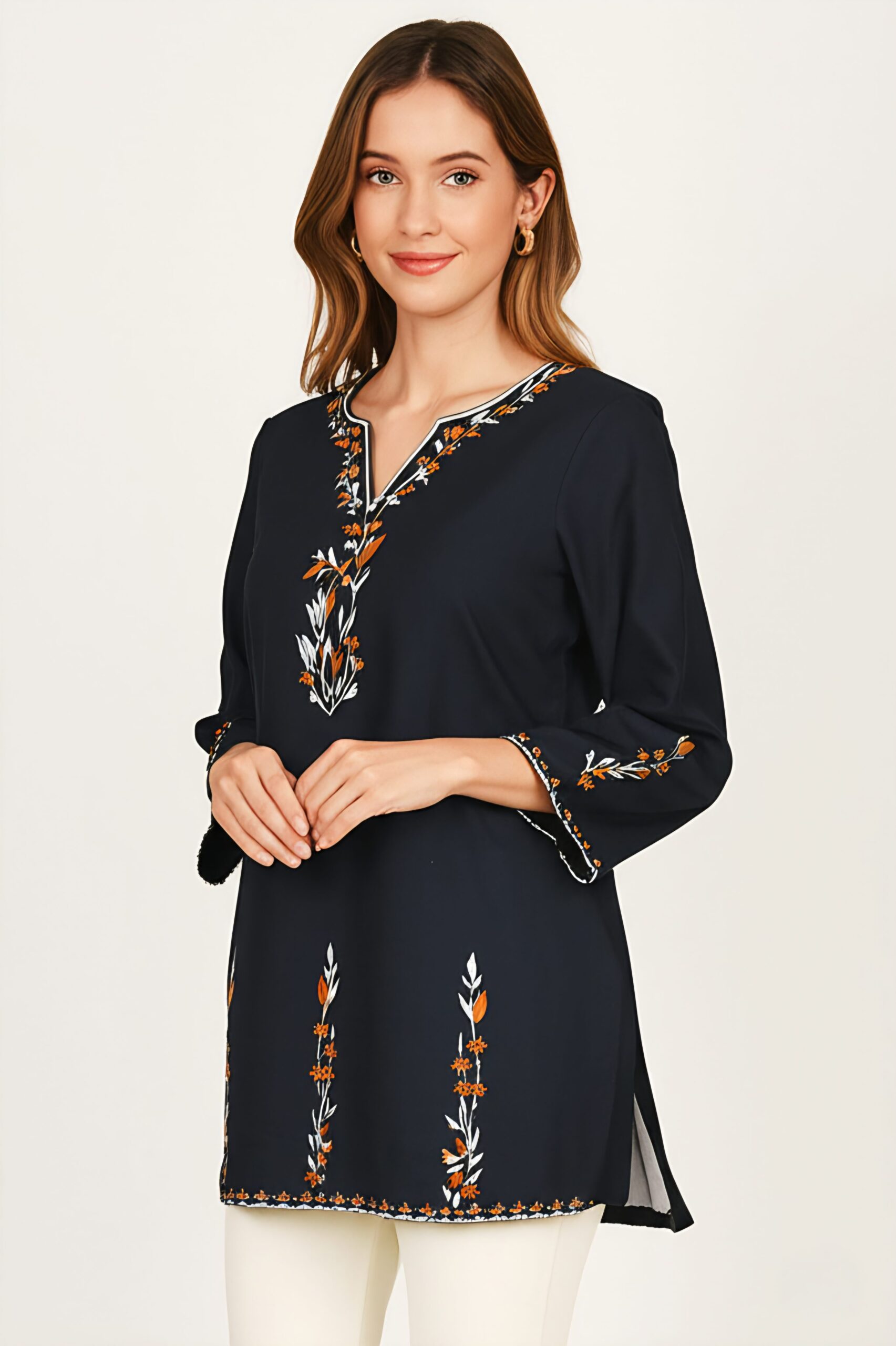 Model wearing a black kurti with orange and white floral embroidery on the v-neck and cuffs.